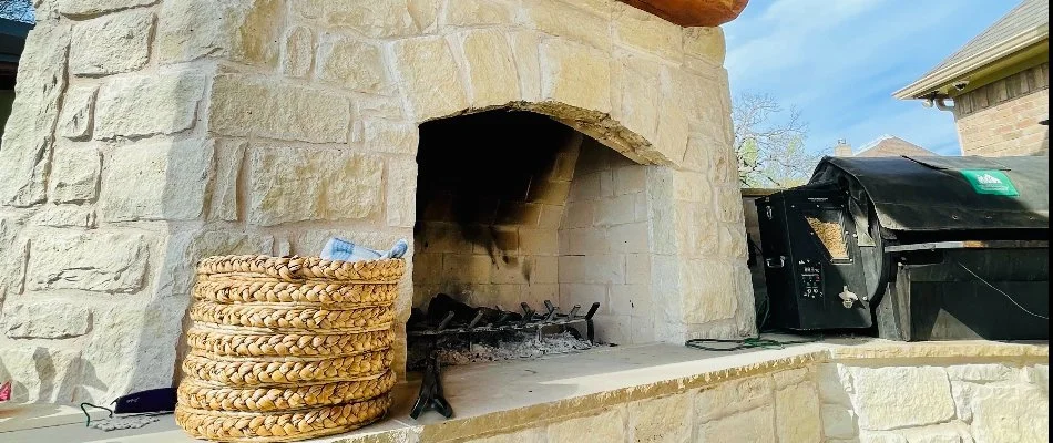 A stone fireplace underneath a wood pavilion in North Texas.